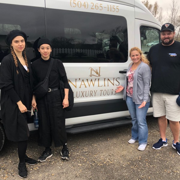 a group of people standing in front of a car posing for the camera