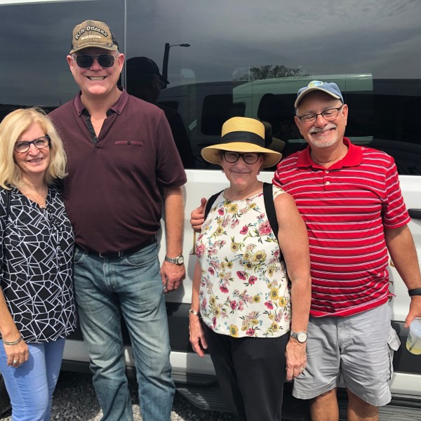 a group of people standing in front of a car posing for the camera