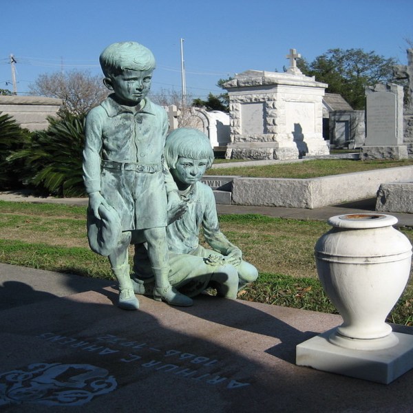 a statue of a man and a woman sitting in a parking lot