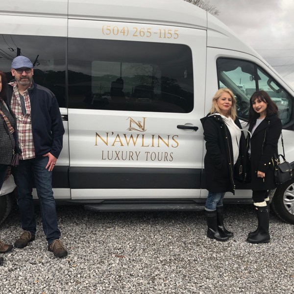 a group of people standing in front of a car posing for the camera