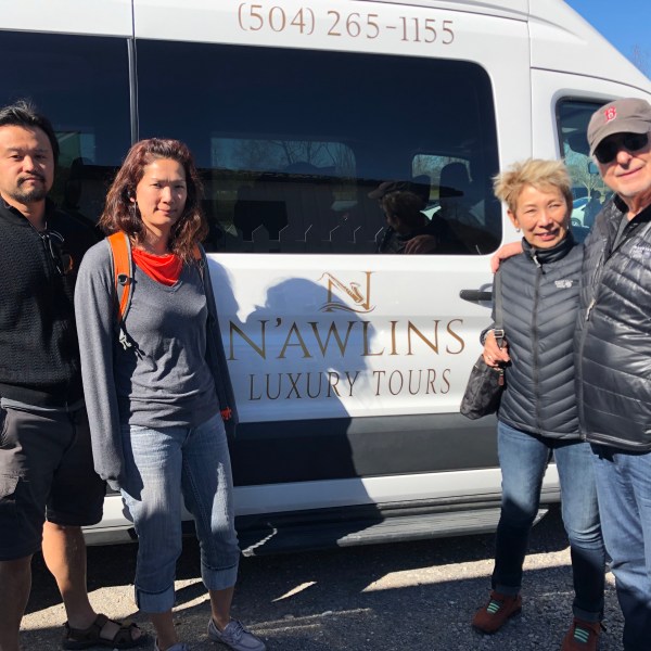 a group of people standing in front of a car posing for the camera